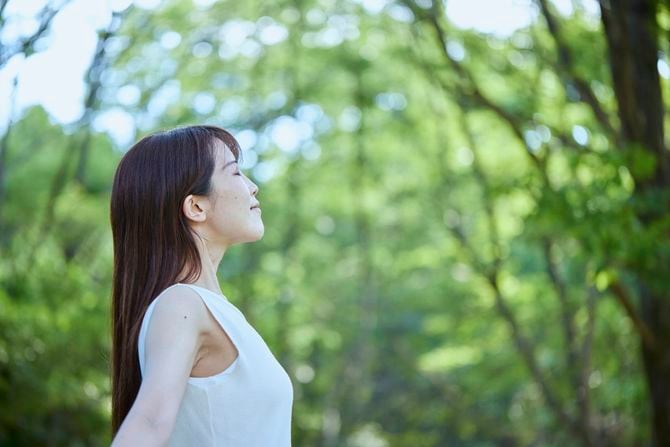 森の中でくつろぐ若い女性