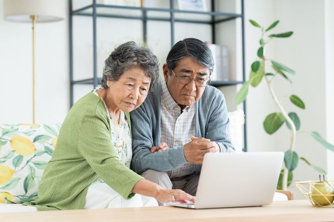 リビングでパソコンを使う高齢のカップル