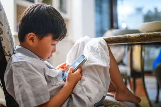 スマートフォンでゲームをする少年