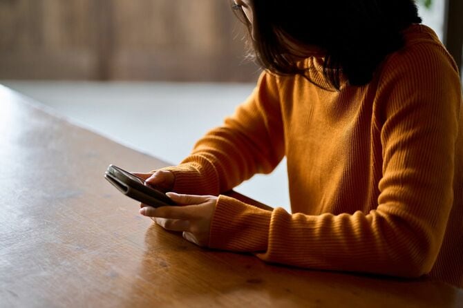 スマホを見て落ち込む女性