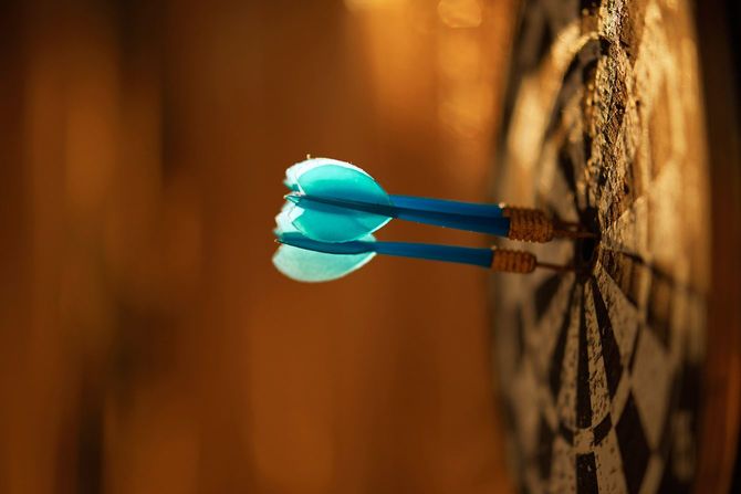 刺さっている青いダーツの矢