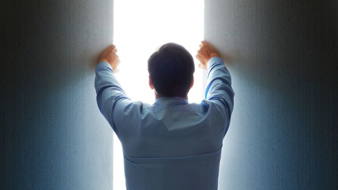 扉に手をかけた男性