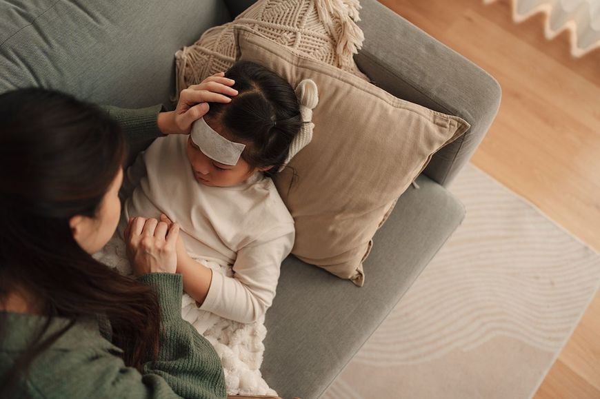 風邪の子供の面倒をみる母親