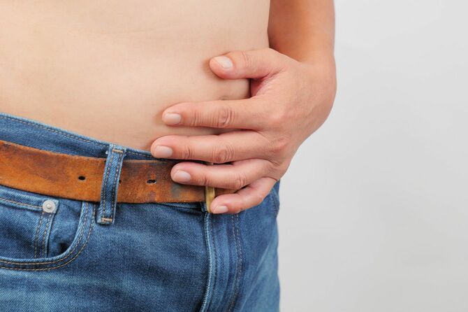 太ったお腹に手を添える男性