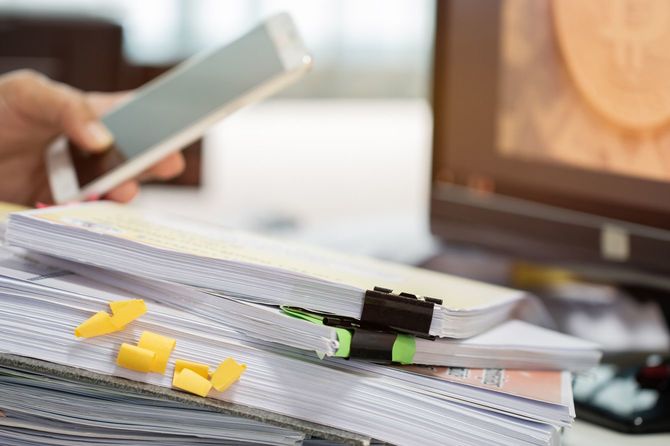 デスクの上に積み上げられた報告書の束