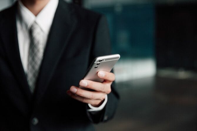 廊下でスマートフォンをチェック