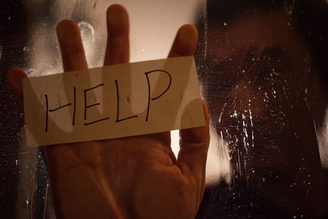 ガラス越しに助けを求める人