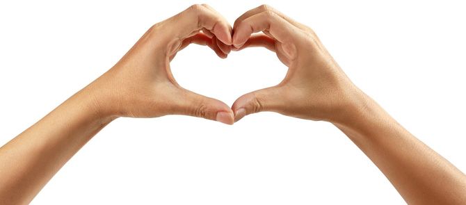 白い背景にハートシンボルを形作る手