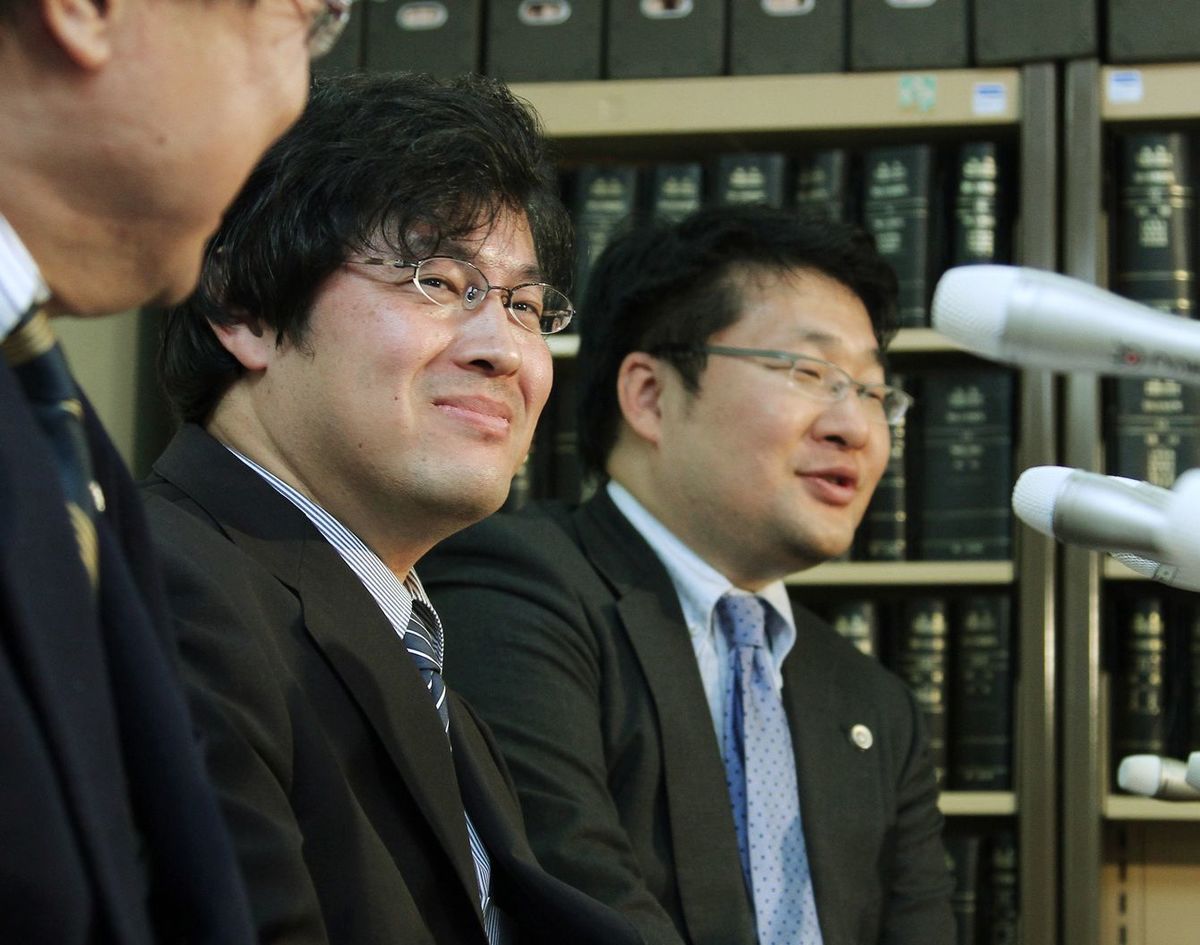 2011年12月20日、検察側上告審棄却が決定し、記者会見で笑顔を見せるファイル交換ソフト「ウィニー」開発者の金子勇氏（右から2人目）（東京・霞が関の司法記者クラブ）