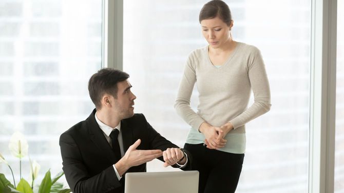 イライラした上司が腕時計を指す