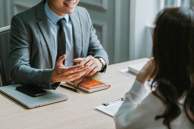 アジアの男性ディレクターが新入社員を募集する面接を受ける