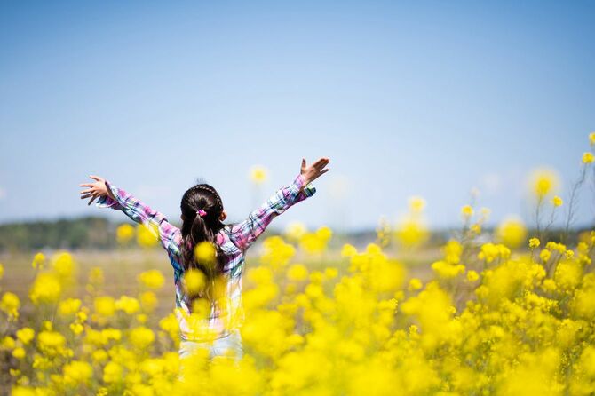 花畑で深呼吸をしている少女