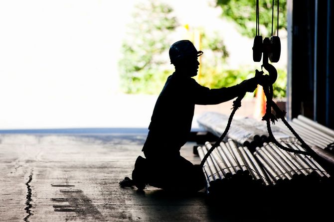 クレーンに資材をかける作業員