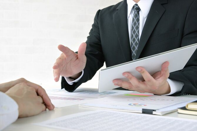 タブレット端末を片手に説明している男性