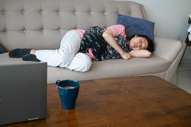 ソファに横たわって眠る人