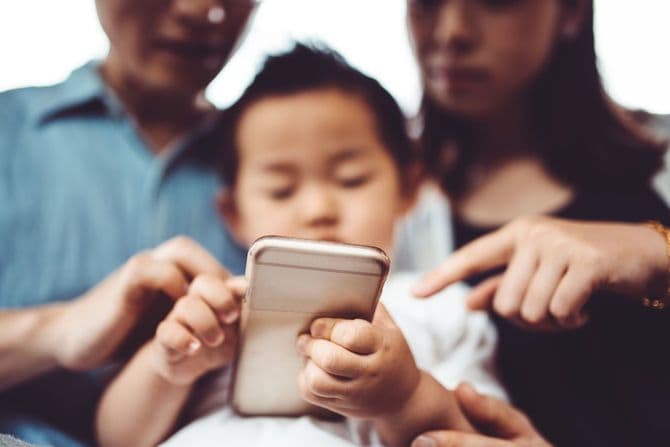 息子と一緒に携帯電話を使用する両親