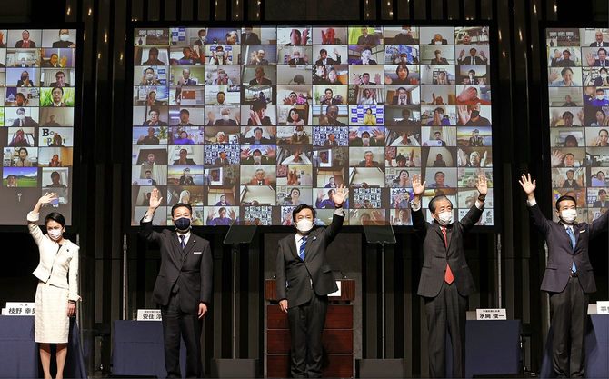 立憲民主党の定期党大会で、オンラインの参加者に壇上から手を振る枝野幸男代表（中央）ら