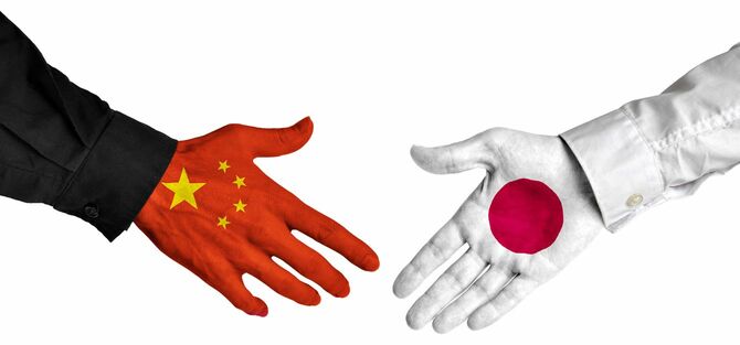 旗を描いた手で中国と日本の指導者の間の外交的握手