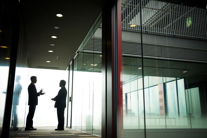 オフィスの廊下で話し合うビジネスマン