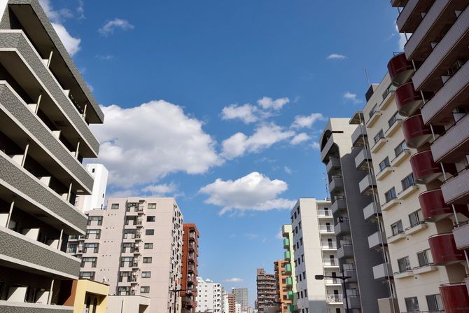 マンションが立ち並ぶ通りから青い空が見える
