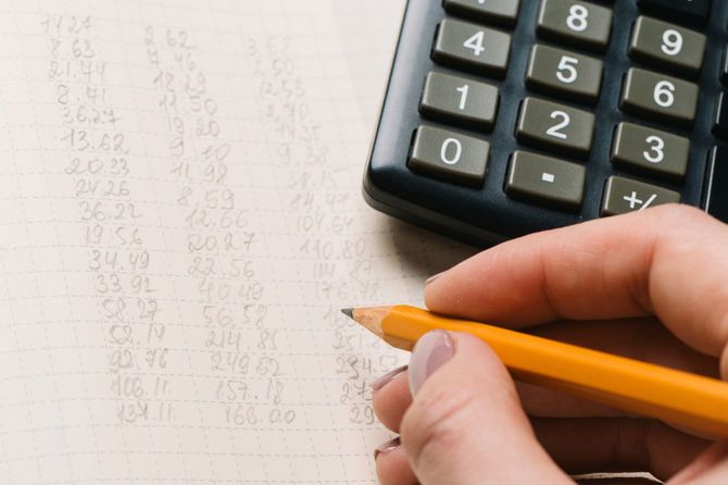 電卓を横に置いて鉛筆で数字を書く人