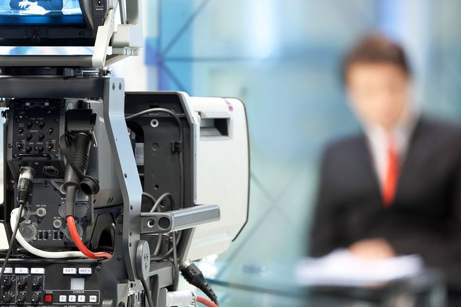 テレビカメラの前にぼやけたニュースキャスター