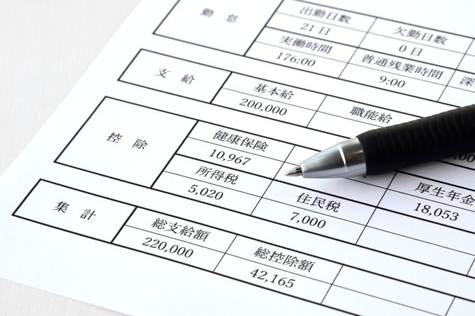 給与明細の所得税の項目に向けて置かれたボールペン