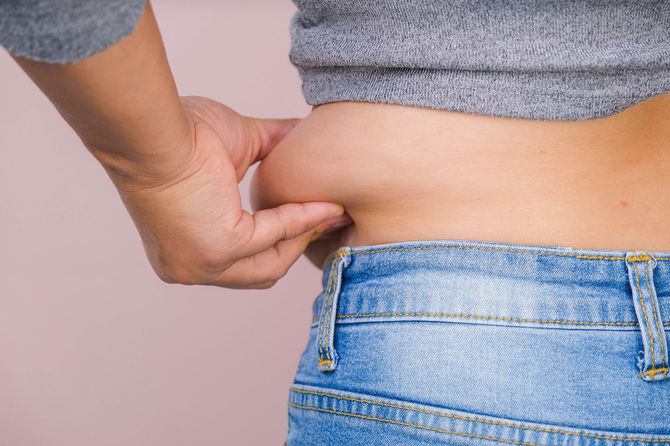 自分のおなかの肉をつまむ人