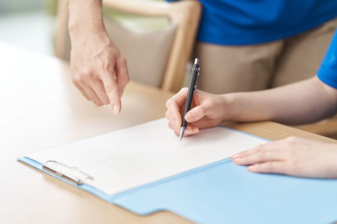 記入書類の指摘を受けているシニアの手元