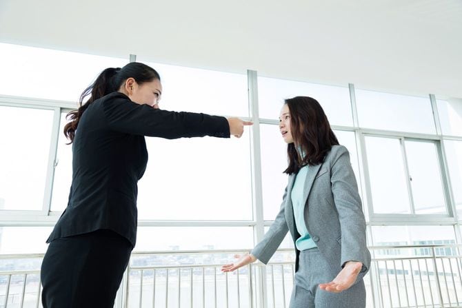 指を指して激しく叱責する女性と困惑する女性