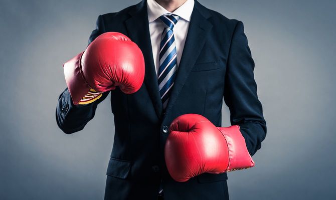 ボクシンググローブをはめたビジネスパーソン