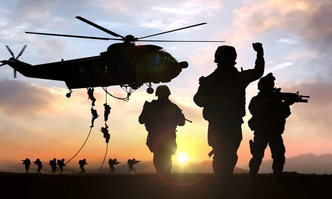 軍事作戦中、夕陽に照らされる兵士たちのシルエット