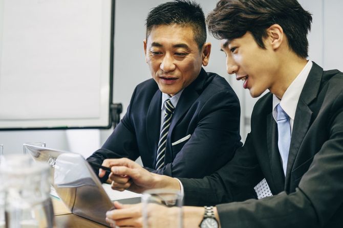 コンピュータを見る2人の同僚 