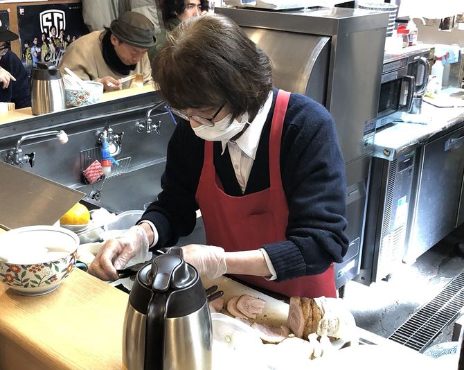 営業中にラーメンのトッピングの準備をする妻の多賀子さん。