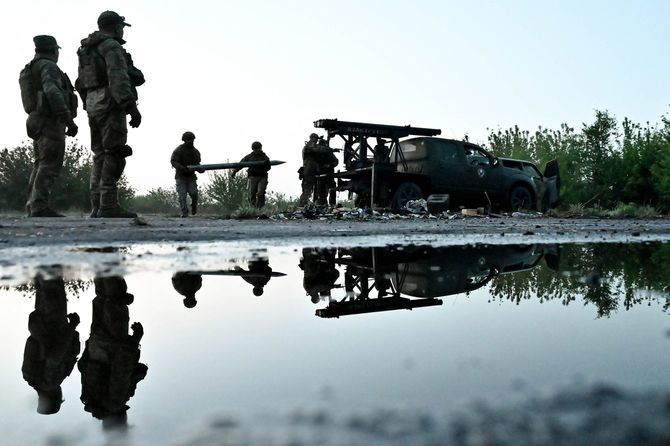 2024年4月27日、ウクライナ南東部ザポリージャ地方で、ロシア軍から鹵獲した多連装ロケット発射管と、ピックアップトラックに搭載された照準器を積み込むステップ・ウルブズの兵士たち。