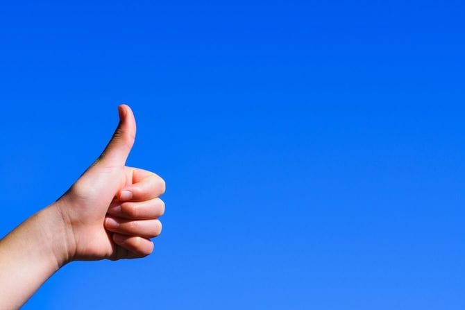 真っ青な空に向かってサムズアップ