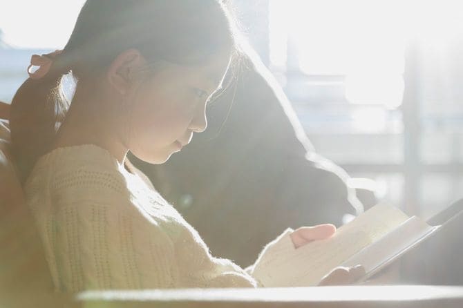 ソファーで本を読んでいる女の子