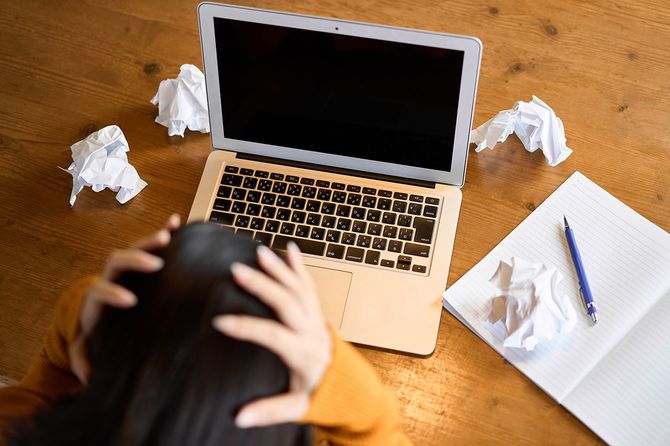 コンピューターの仕事で立ち往生している女性