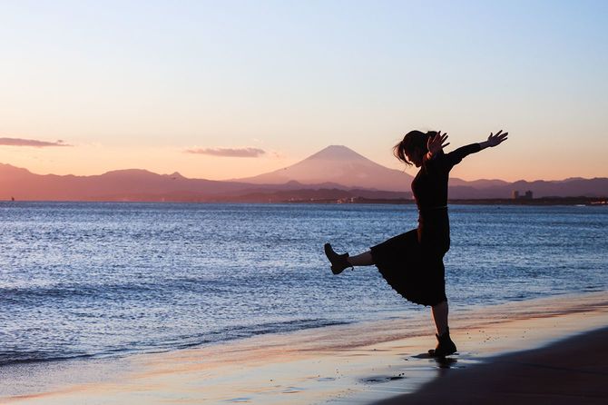 サンセットビーチでリラックス美しい若い女性