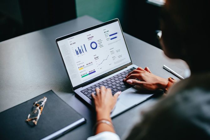 ノートパソコンでビジネスレポートを入力する女性