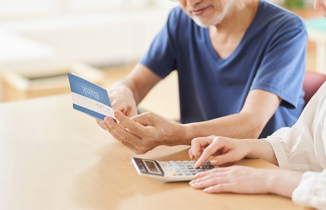 通帳を確認する高齢者