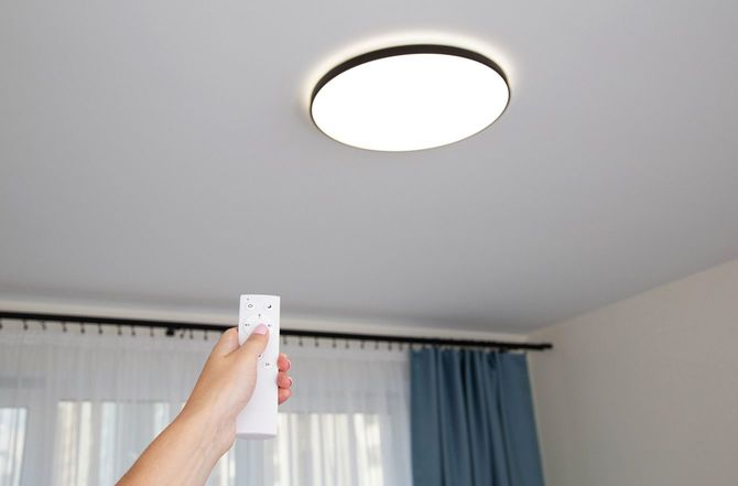 リモコンで照明の調整をしている手元