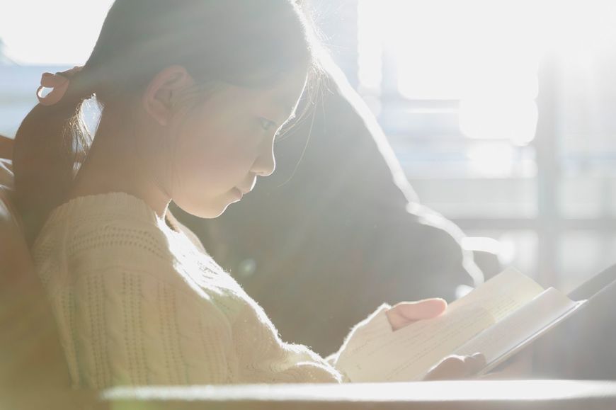 ソファーで本を読んでいる女の子