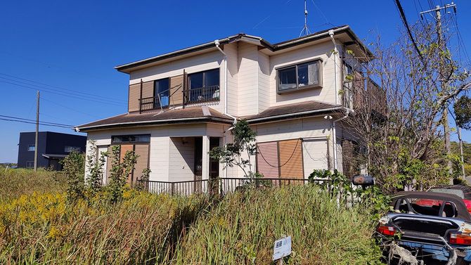 地盤沈下によって骨組みごとゆがみ、放棄されている空き家。（千葉県九十九里町）