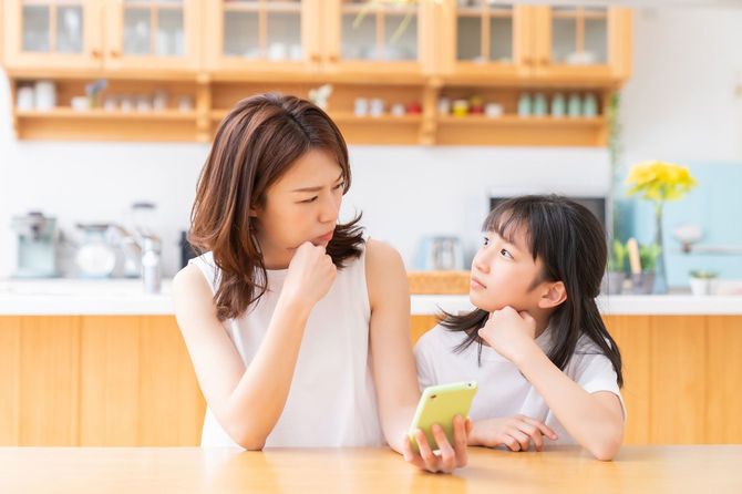 スマートフォンを手に考える親子