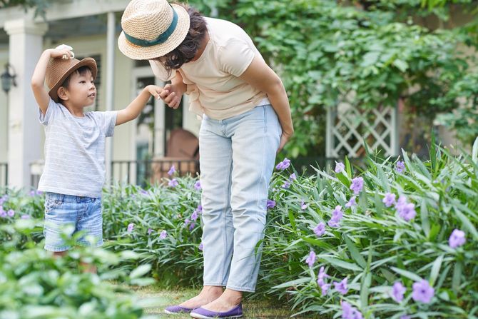 夏の庭で母親に尋ねる子ども