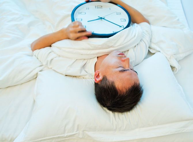 時計を抱えて寝る人のイメージ
