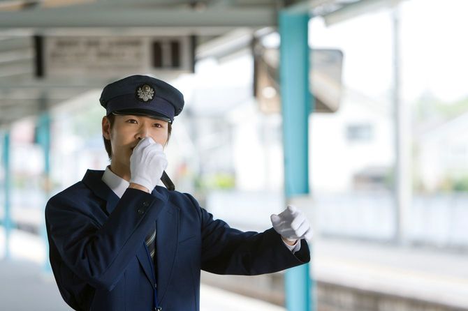 ホームでアナウンスを行う駅員