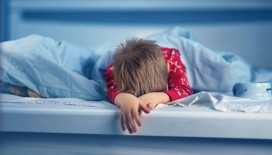 ベッドに横たわっている眠い男の子