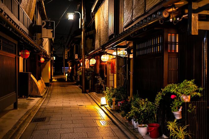 居酒屋の入り口に赤い提灯の紙ランプが照らされた暗い夜の祇園地区の狭い空の路地